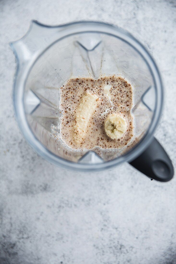 An almond milk and banana smoothie in a blender