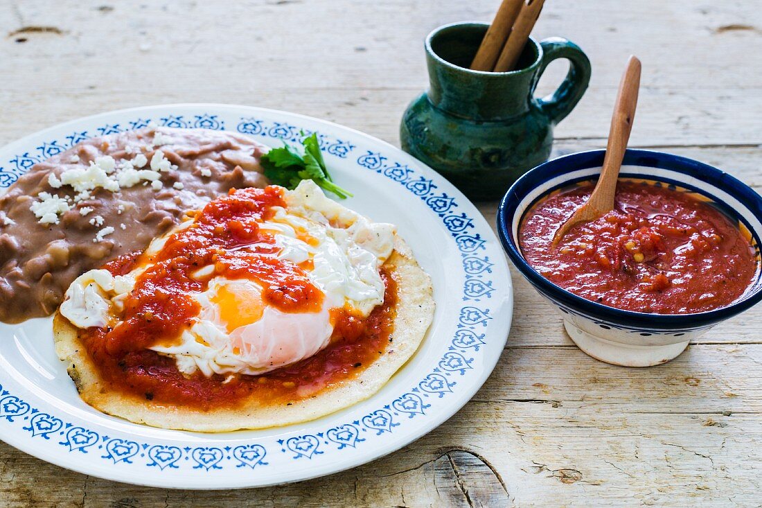 Huevos Rancheros (Spiegelei auf Maistortilla mit gebratenen Bohnen und Tomatensauce, Mexiko)