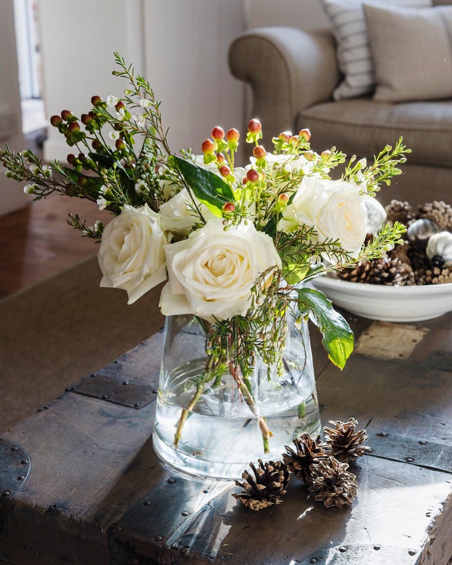 Winterlicher Strauß mit weißen Rosen und Zapfen-Deko