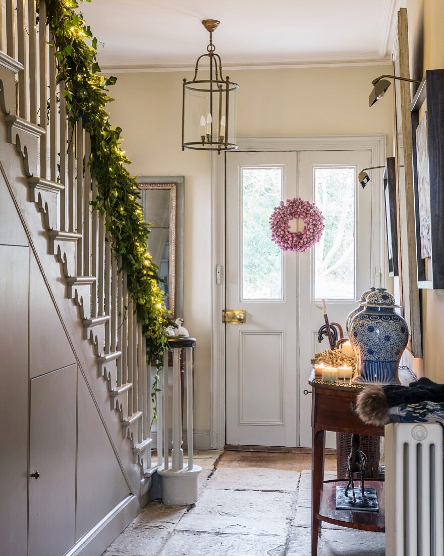 Festively decorated hall with garland along staircase handrail
