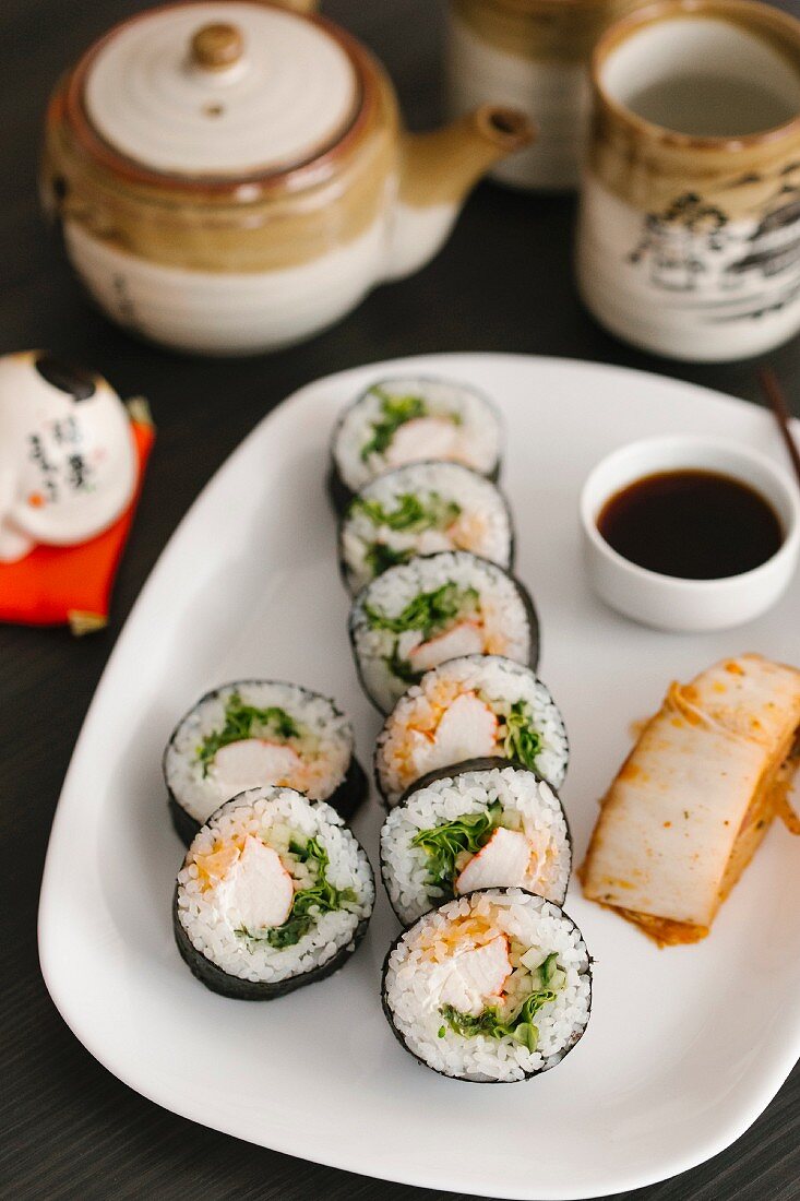 Maki-Sushi mit Sojasauce auf Servierplatte