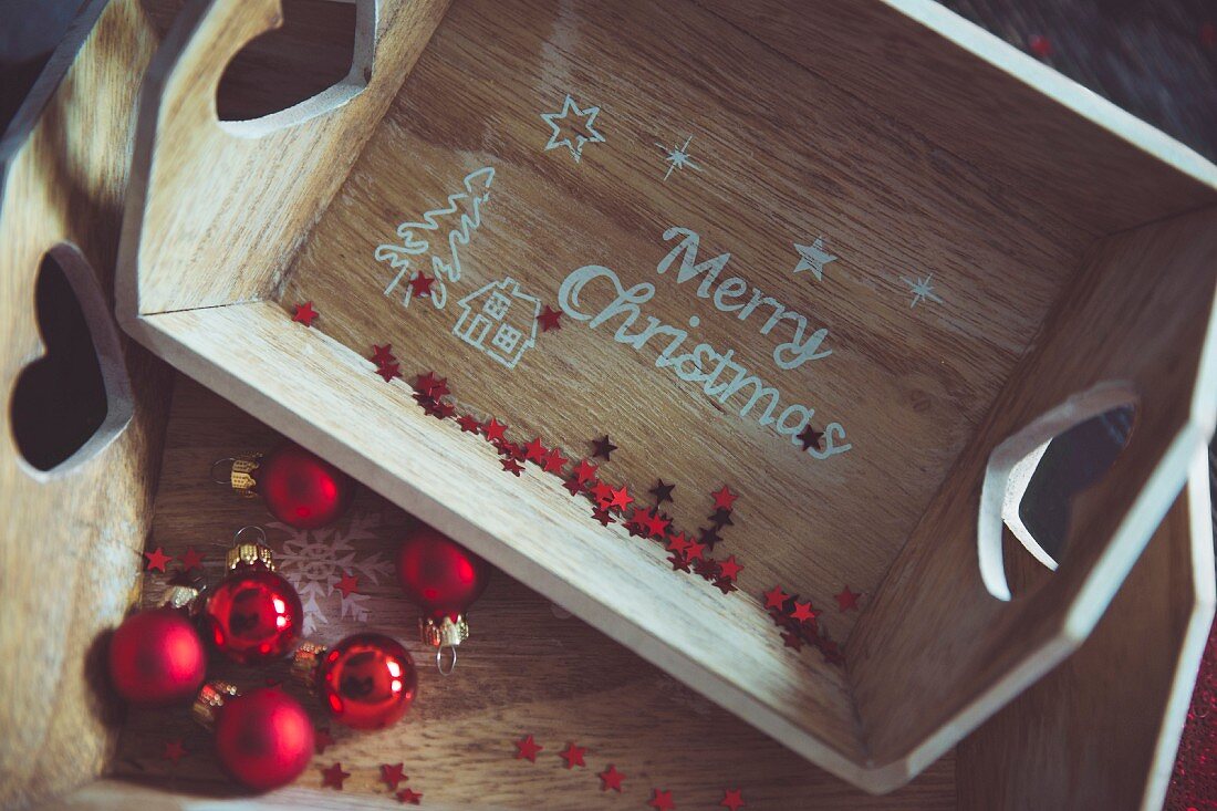 Holzkästen mit 'Merry Christmas' Schrift und roten Weihnachtskugeln