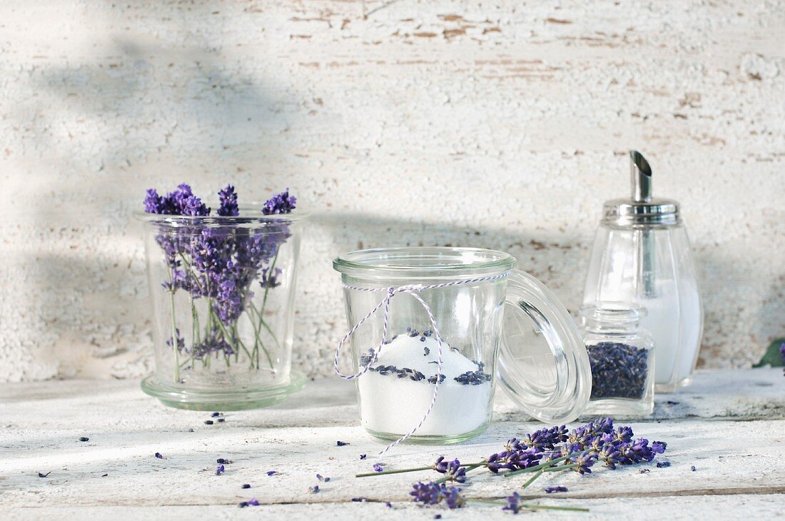 Lavendelzucker in einem Glas, daneben Lavendelblüte