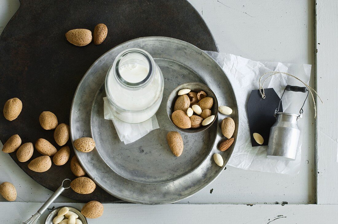 Glass bottle of homemade almond milk and almonds