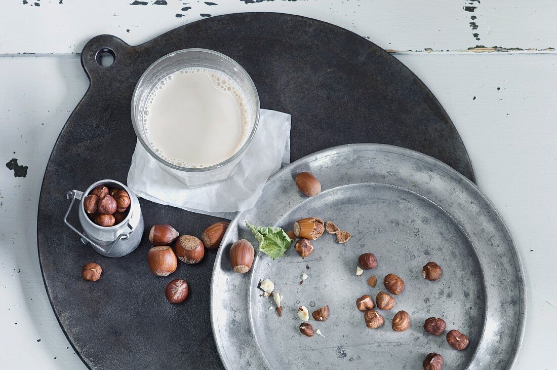 Glass of homemade hazelnut milk and hazelnuts