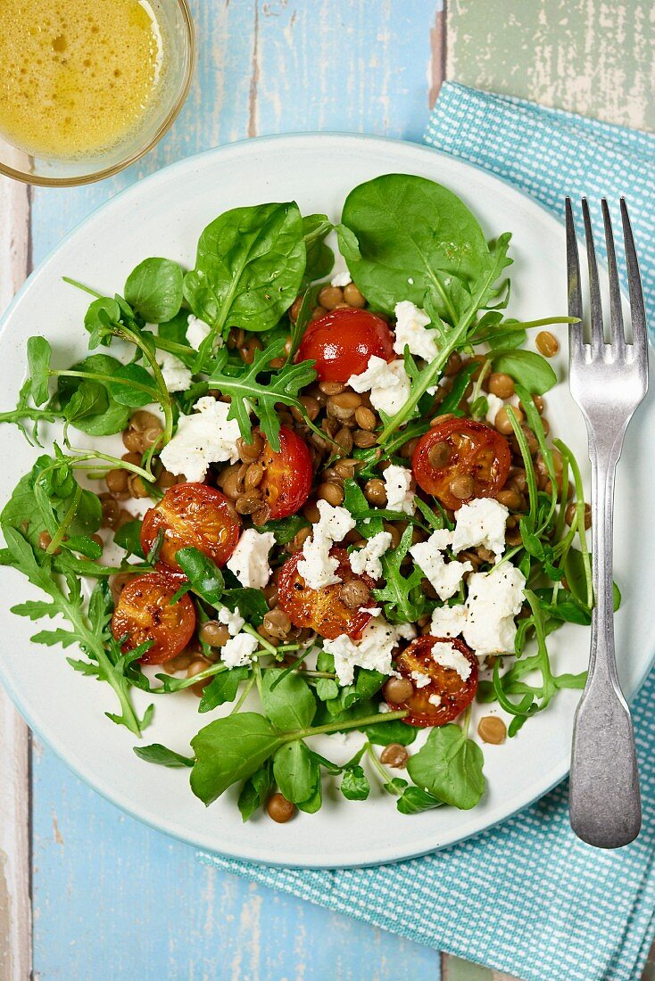 A mixed leaf salad with feta, lentils and cherry tomatoes