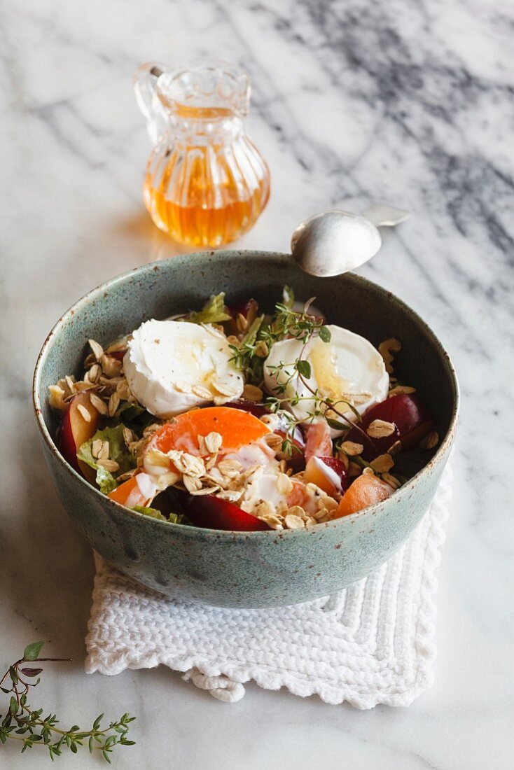 Hearty oat flakes bowl with fruits, goat cheese and thyme