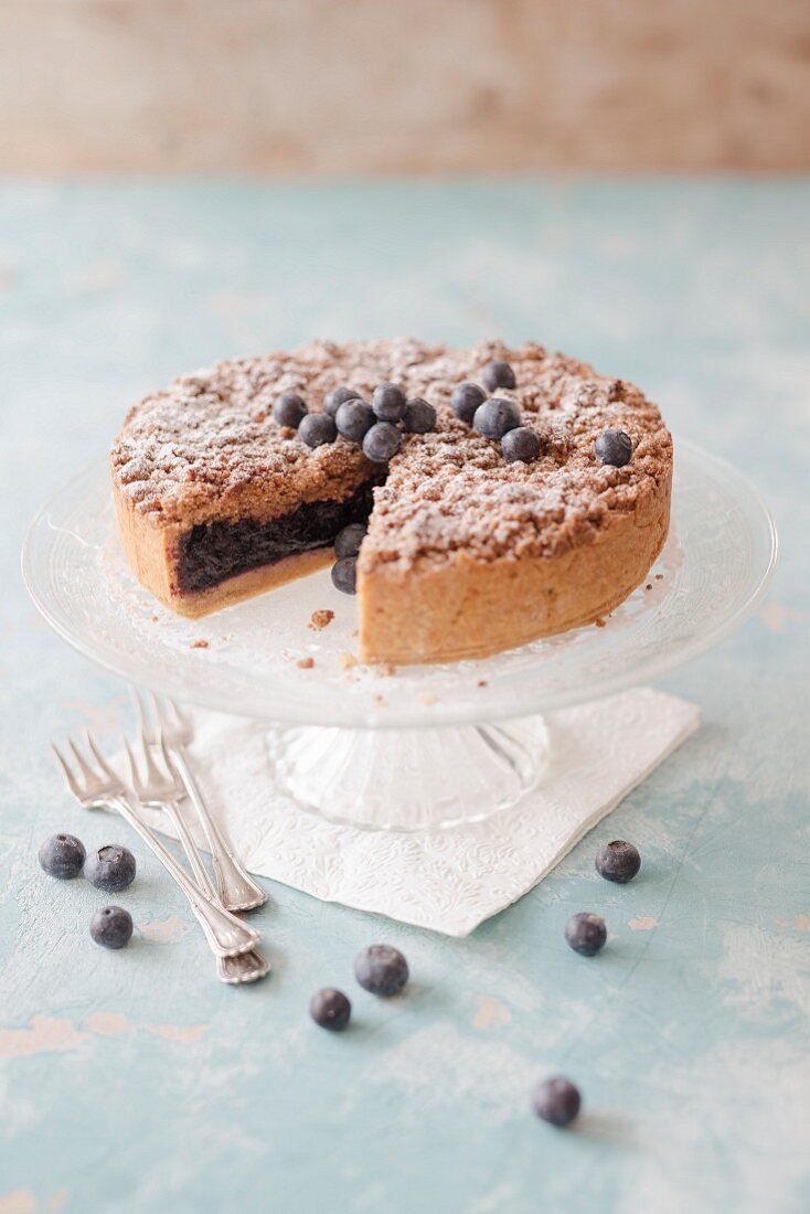 Blueberry crumble cake on a cake stand (vegan)