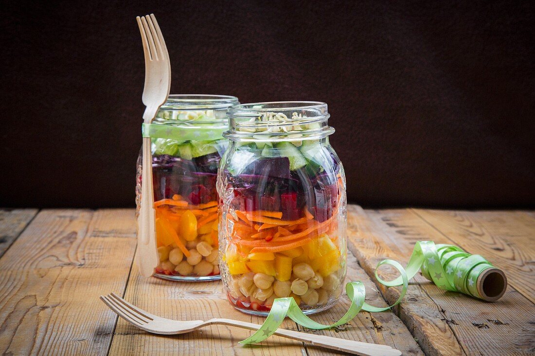 Two glasses of rainbow salad with chick-peas and different vegetables