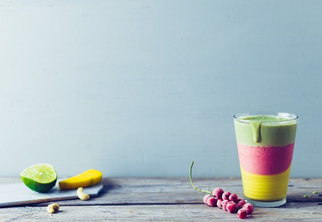 A layered smoothie with kale, mango and redcurrants in rainbow colours