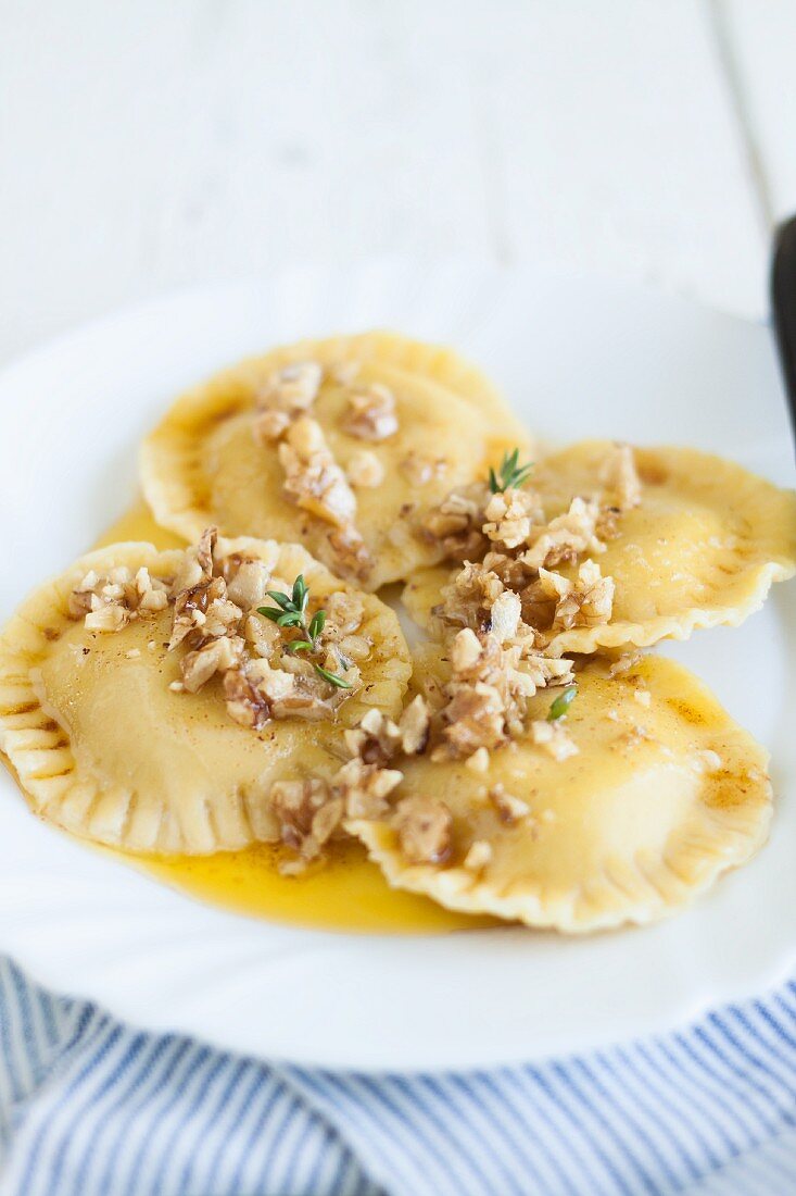 Pumpkin ravioli with melted butter and chopped walnuts
