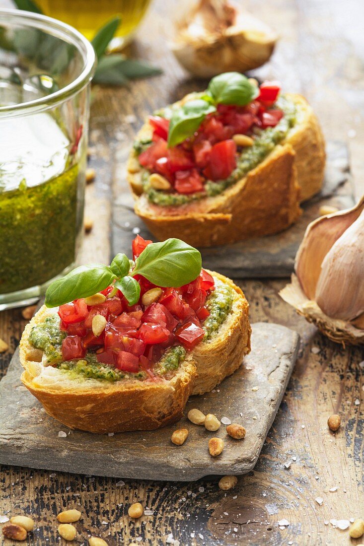 Bruschetta with basil pesto, tomatoes, pine nuts and basil leaves