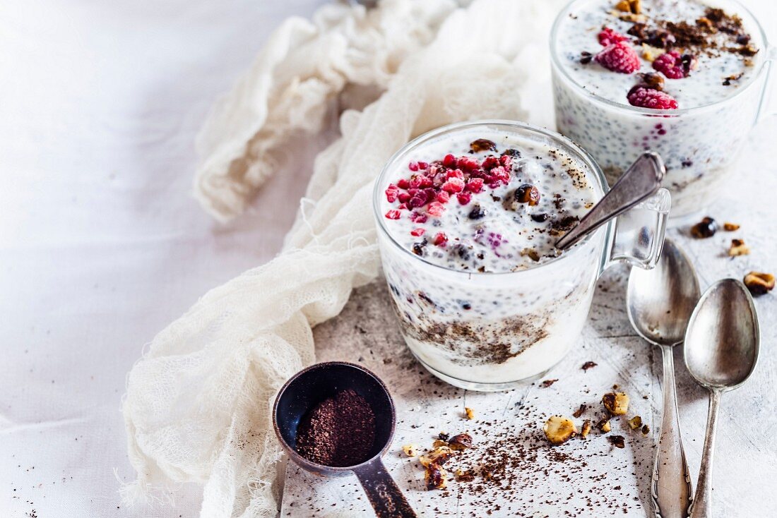 Joghurtdessert mit Bananenpüree, Chiasamen, gefrorenen Himbeeren, gerösteten Haselnüssen und Kaffee)