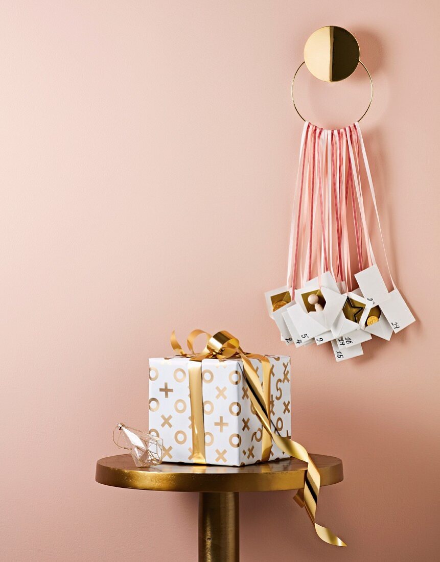 Advent calendar with envelopes over a gift in gold