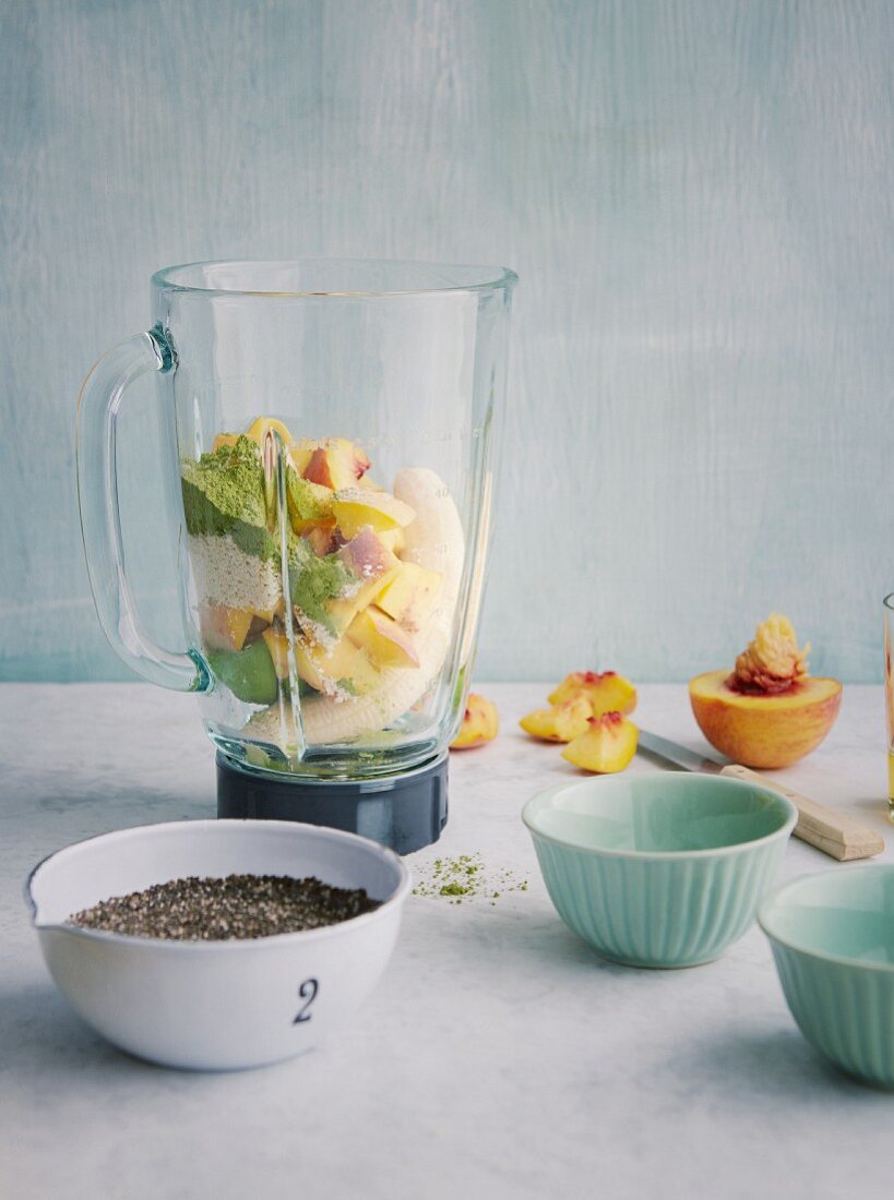 Ingredients for green matcha and peach pudding with avocado in a mixer