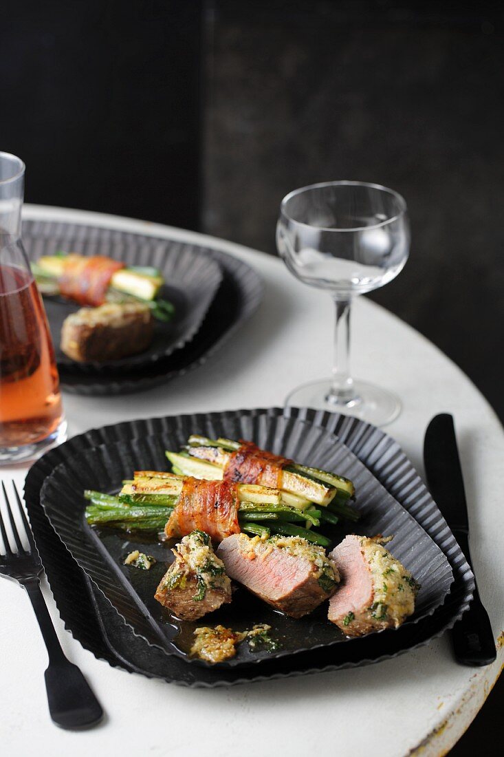 Lamb fillet with a herb crust and bacon-wrapped green beans