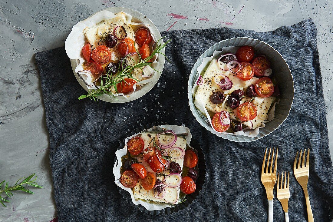 Feta with olives, tomatoes and herbs baked in the oven