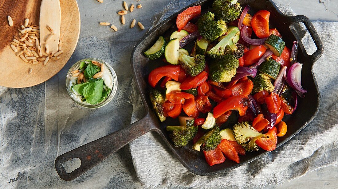 Colourful oven-roasted vegetables and a yoghurt and mint sauce