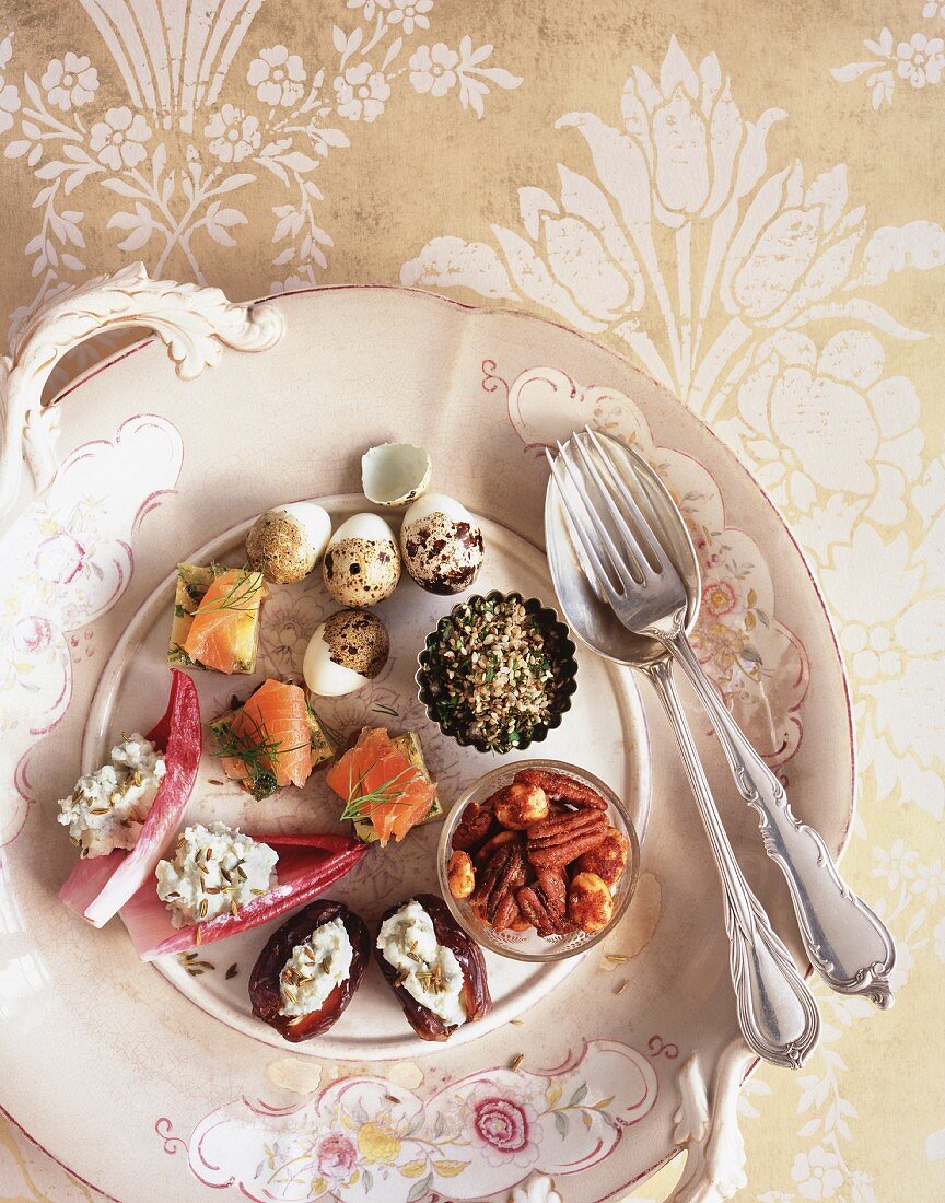 A canapé platter with salmon, walnut, stuffed dates and quail eggs
