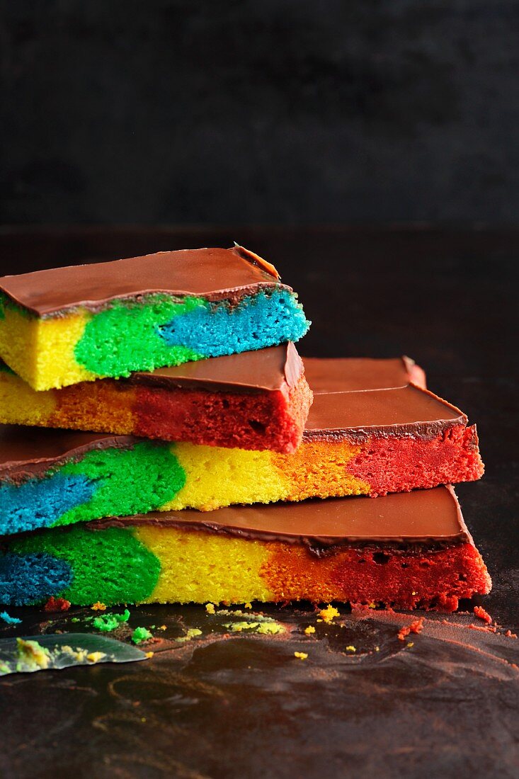 Colourful rainbow cake topped with chocolate glaze