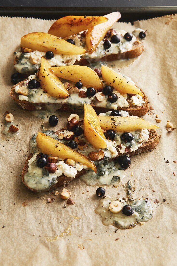 Open sandwiches on rye bread with gorgonzola, caramelised pear wedges and blackcurrants