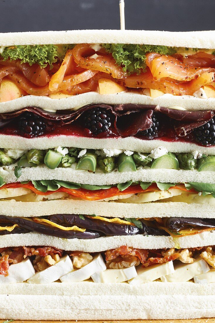 A mega sandwich with fruit, cheese, egg, salmon and venison ham