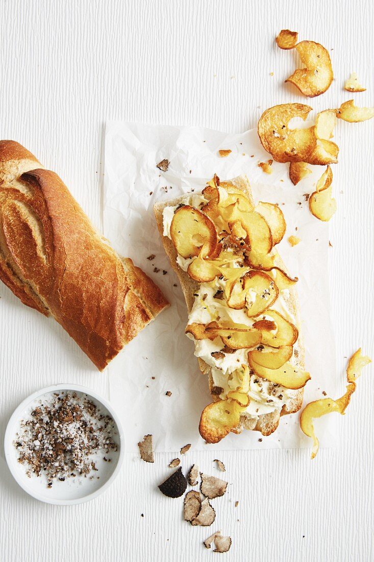 A baguette sandwich with crisps, lemon spread and fresh summer truffle