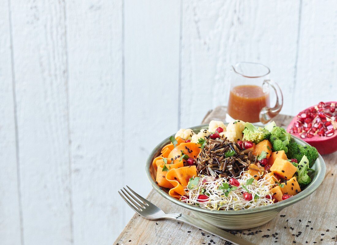 A wild rice bowl with sweet potato, shoots and orange sauce