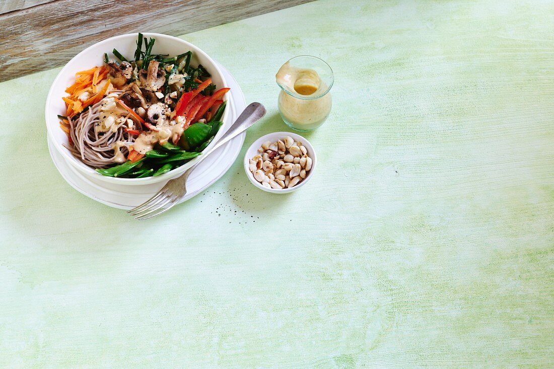 A soba noodle bowl with vegetables and apricot sauce