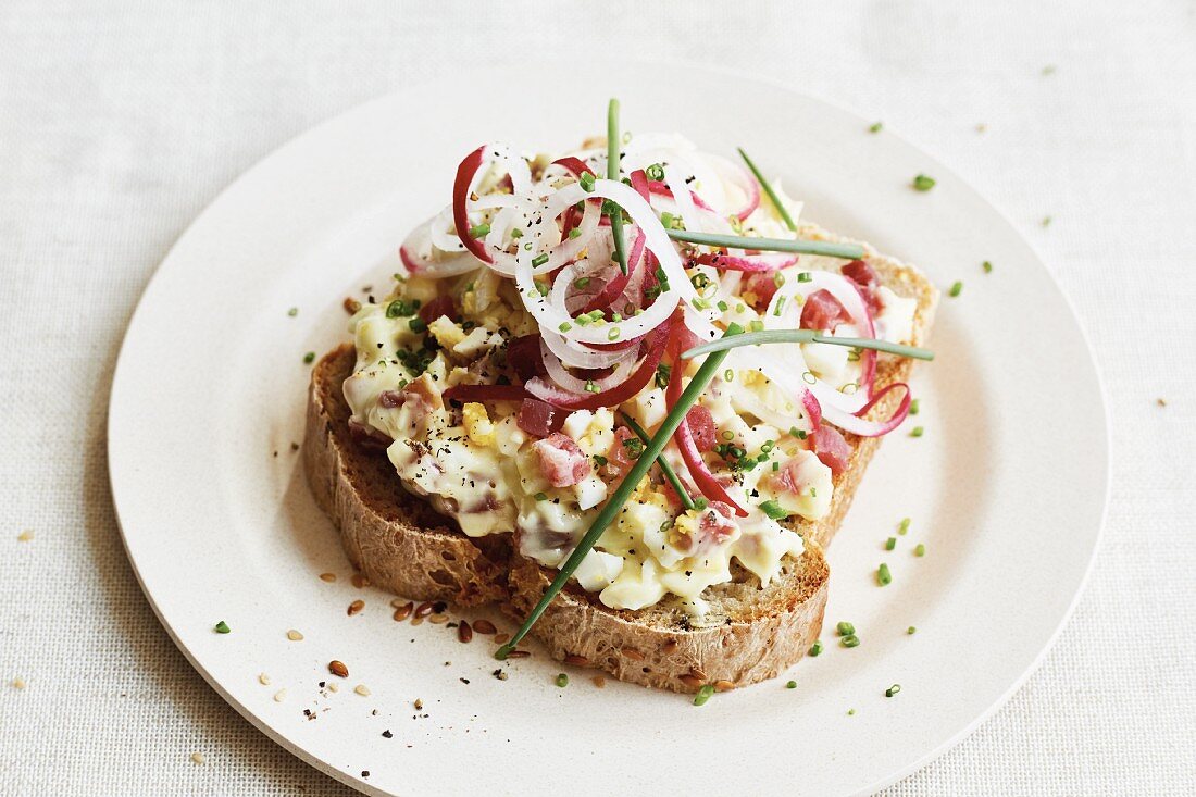 An open sandwich with radishes, hard-boiled egg and cooked ham