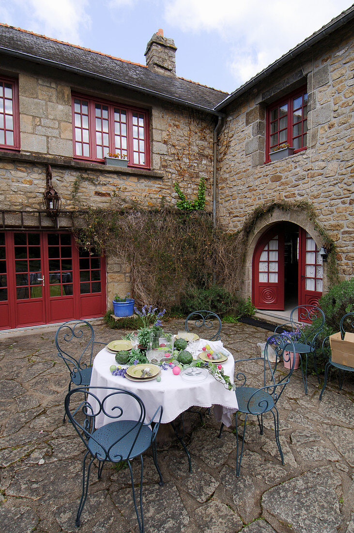 Set garden table in courtyard of French farmhouse