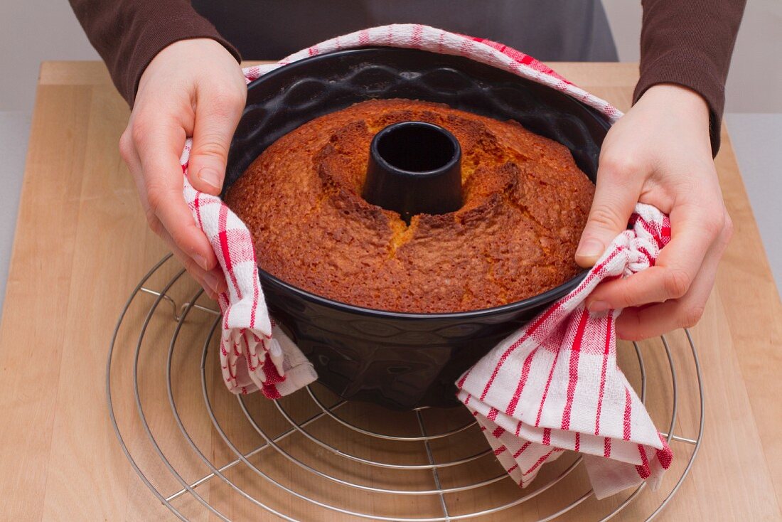 Kuchen aus der Form stürzen - mit einem feuchten Küchentuch umwickeln und durchziehen lassen