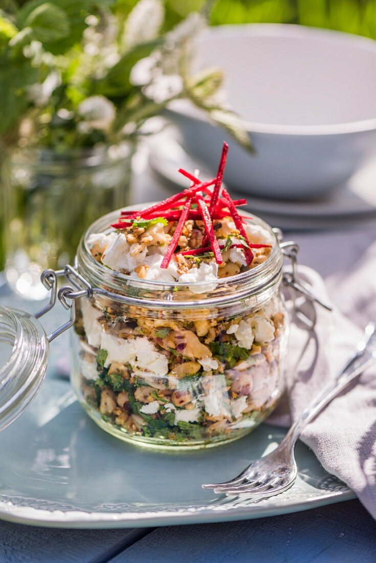 Rice salad with nuts, seeds, feta, coriander and mint in a screw-top jar