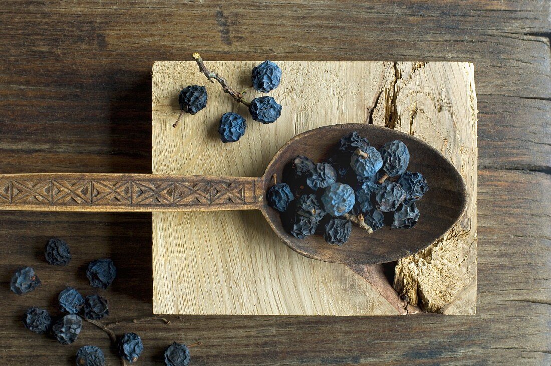 Dried blackthorn fruits on a wooden spoon
