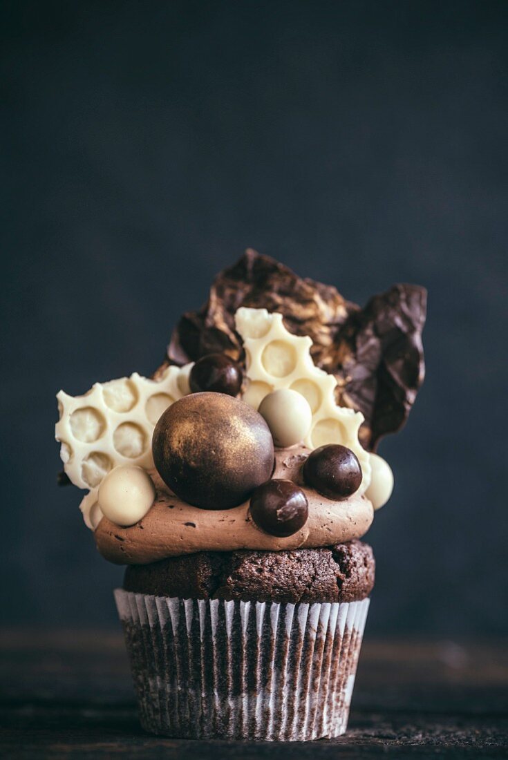 A chocolate cupcake with sweets on the top for a party