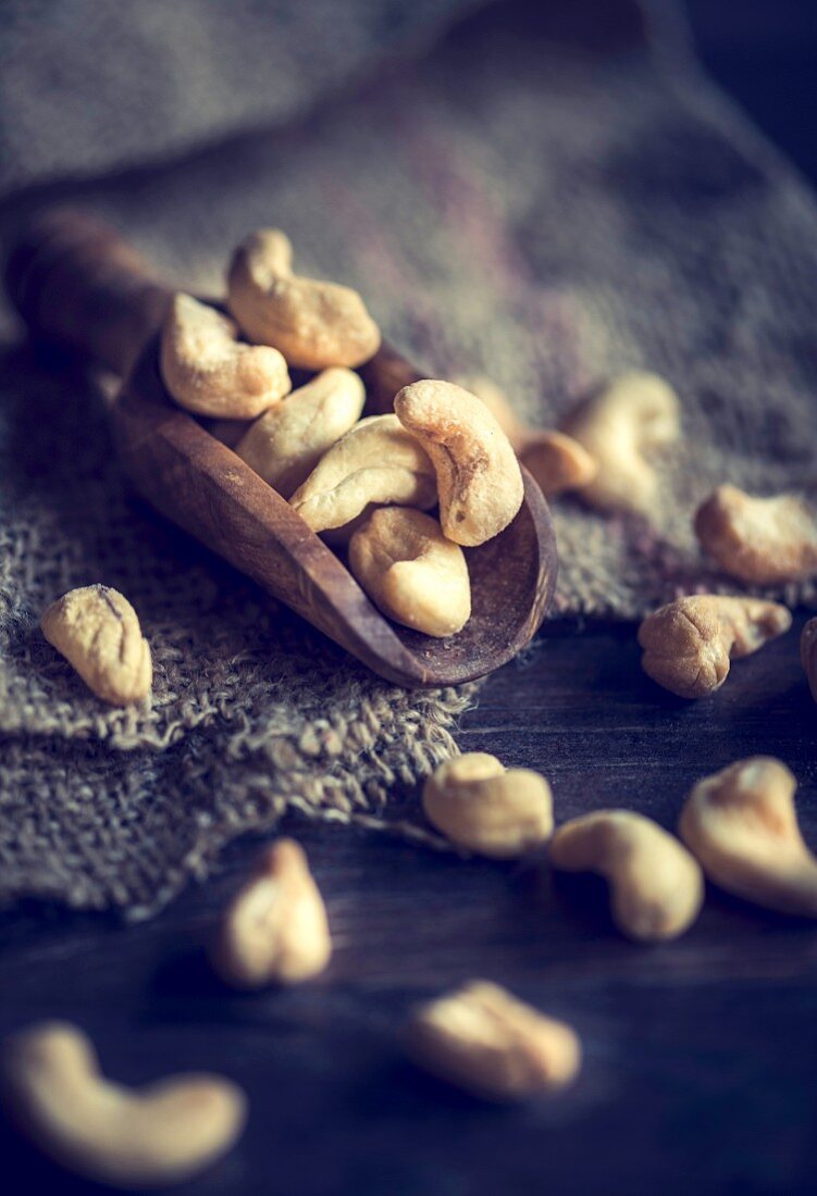 An arrangement of cashew nuts on a wooden scoop