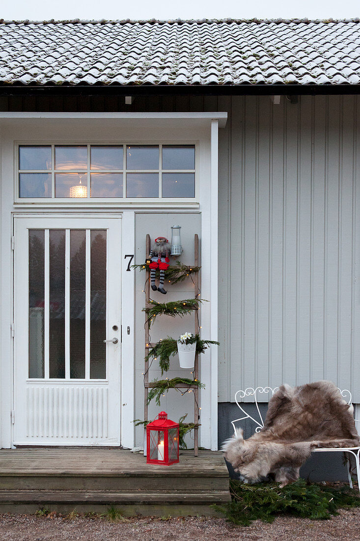 Festively decorated ladder next to front door