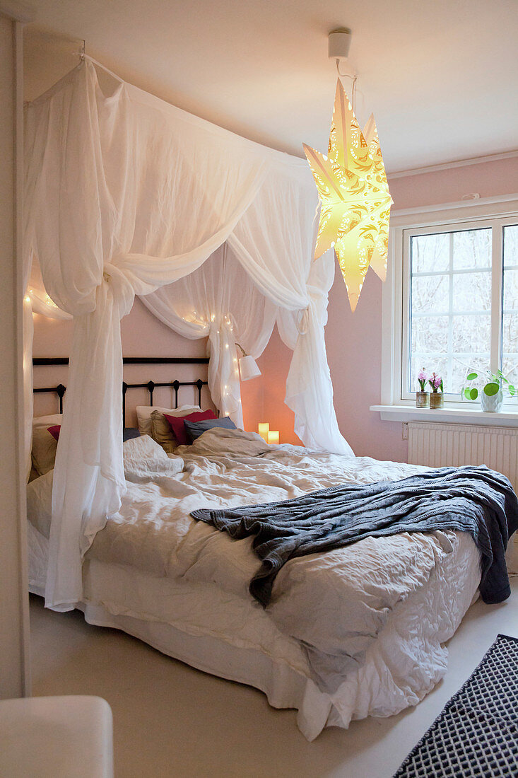Romantic canopy above bed with crumples bed linen