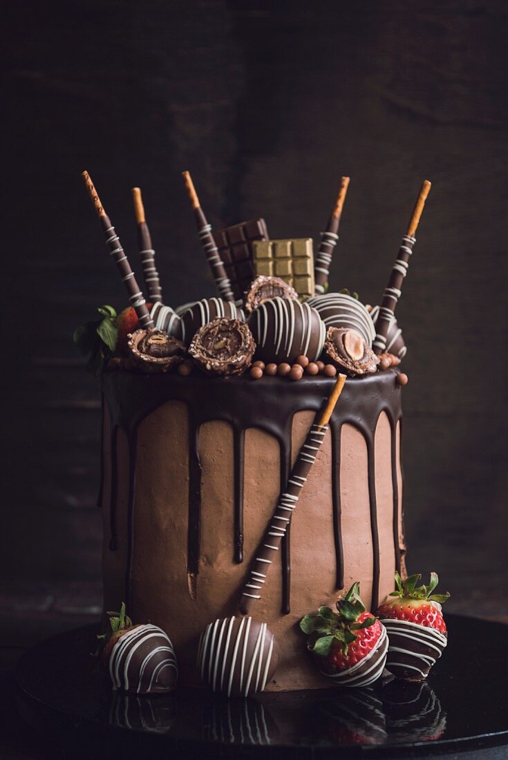Festlicher Schokoladenkuchen, verziert mit Pralinen und Erdbeeren