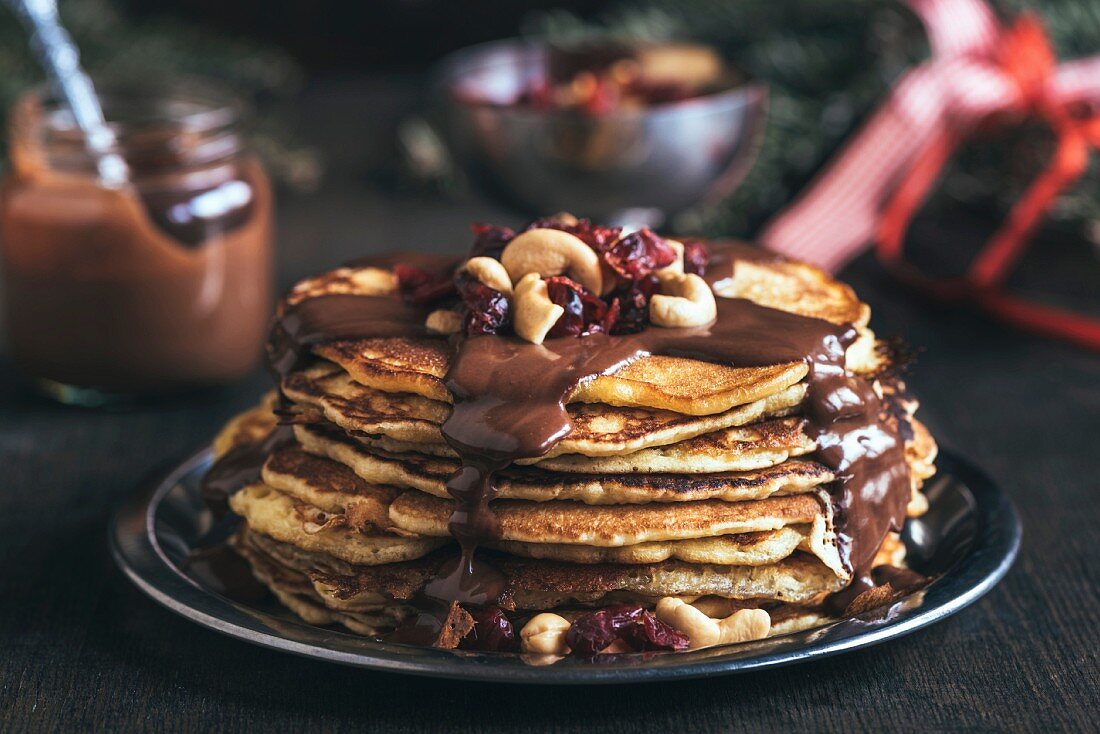 Gestapelte Pancakes mit Schokoladensauce und Nüssen