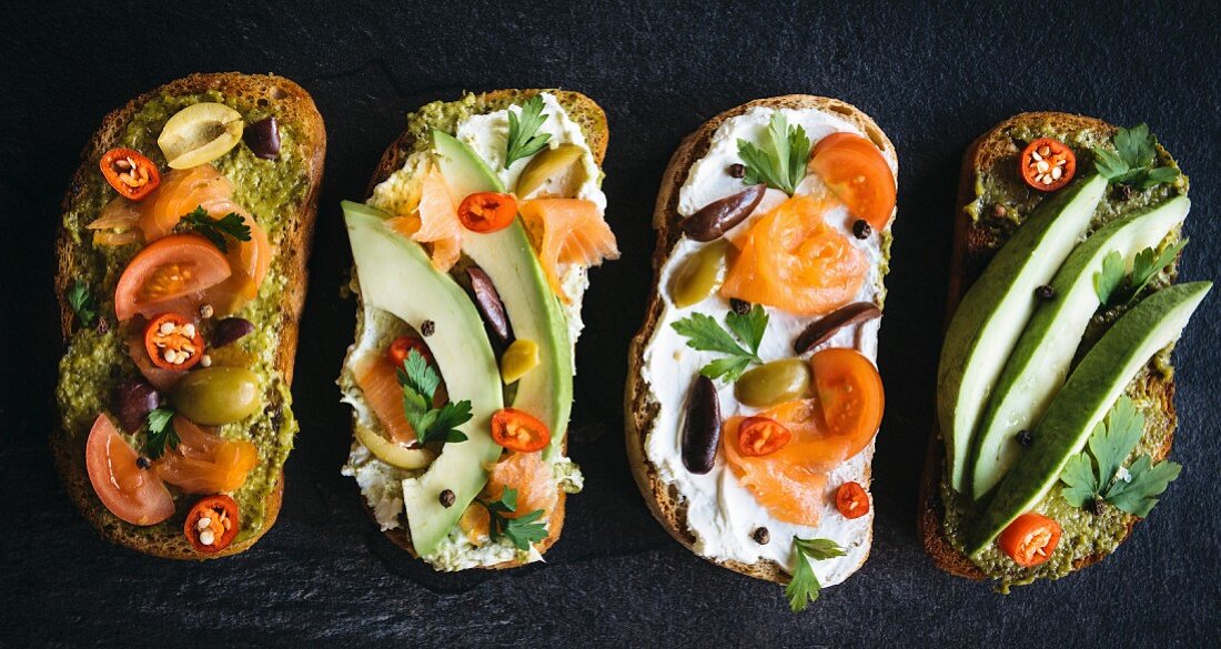 Diet sandwiches with salmon and avocado on dark background