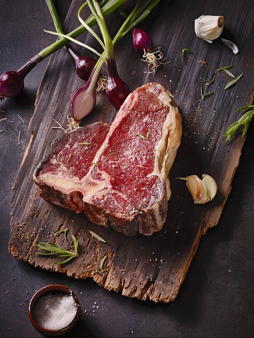 Rohes Dry Aged T-Bone-Steak auf Holzbrett