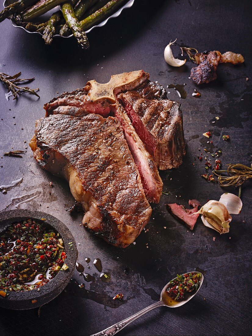 A grilled, dry-aged T-bone steak with chimichurri