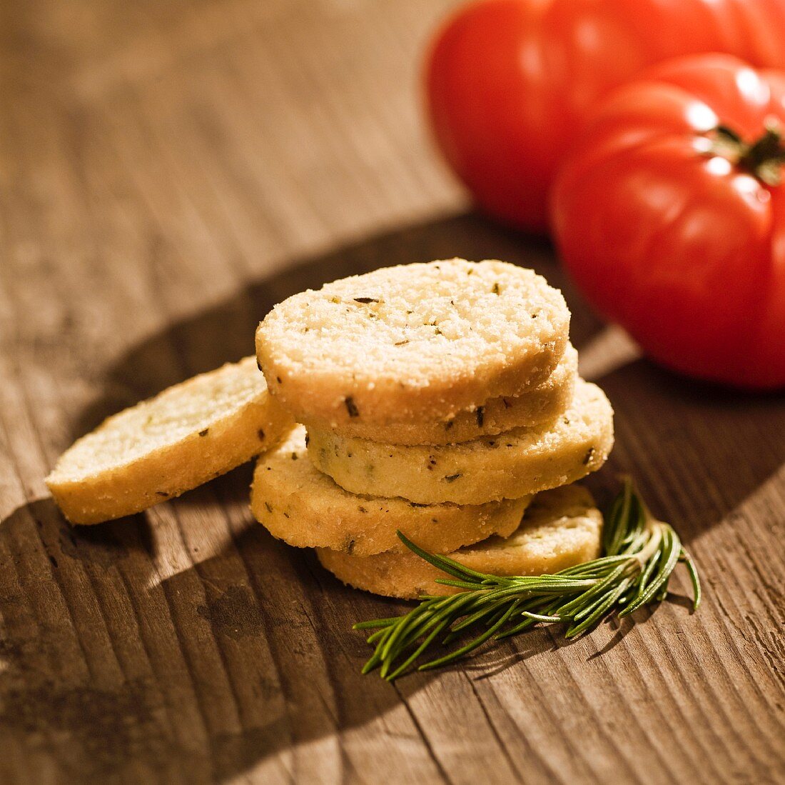 Crostini mit Rosmarin und Knoblauch, daneben Tomaten