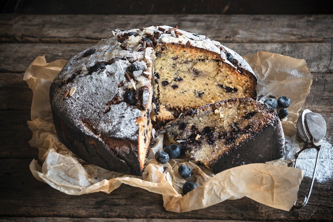 Homemade blueberry cake, sliced, on a wooden background