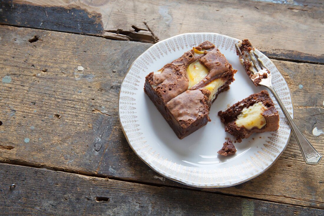 Schokoladen-Vanille-Brownie, angebissen, auf Teller mit Gabel