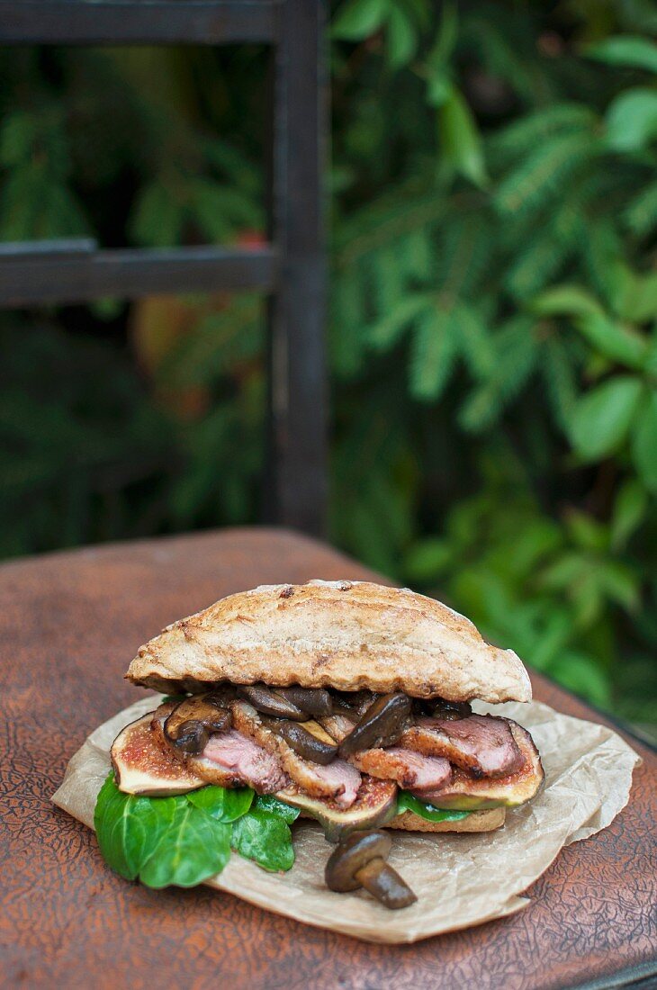 A whole grain sandwich with lamb's lettuce, roasted duck breast and wild mushrooms