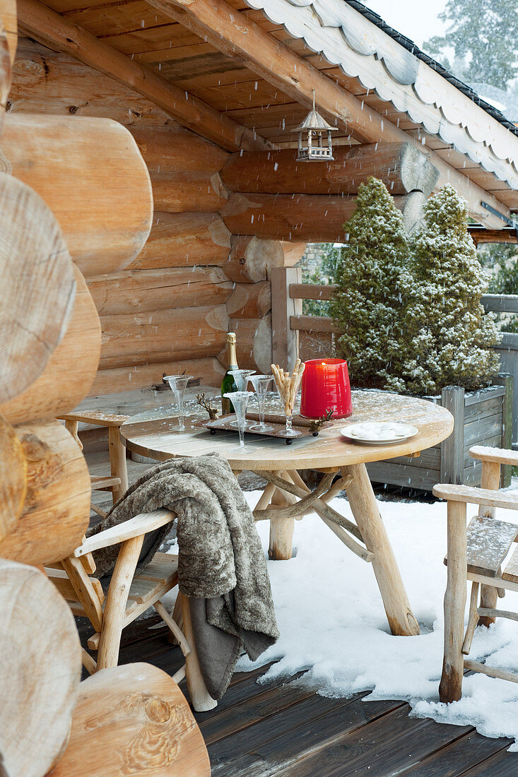 Sitzplatz mit Sekt auf dem verschneiten Balkon