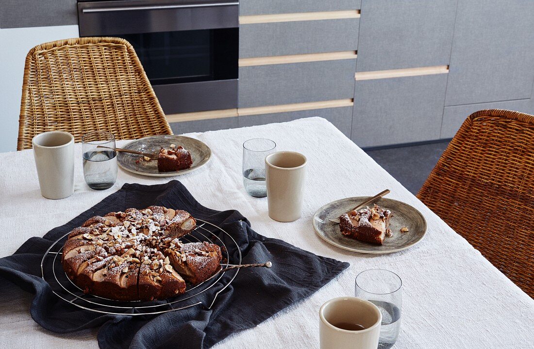 A pear cake on a table set for tea time