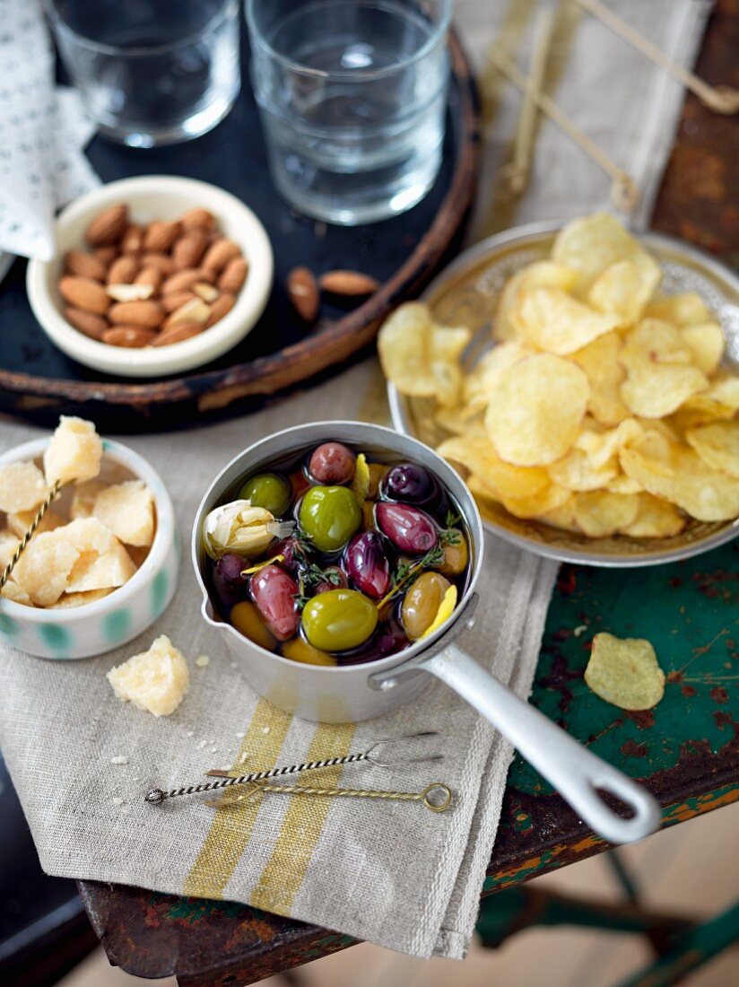 Various snacks (olives, potato chips, Parmesan, almonds)
